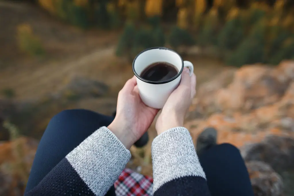 Photo: Drinking cup of coffee on background of autumn mountains